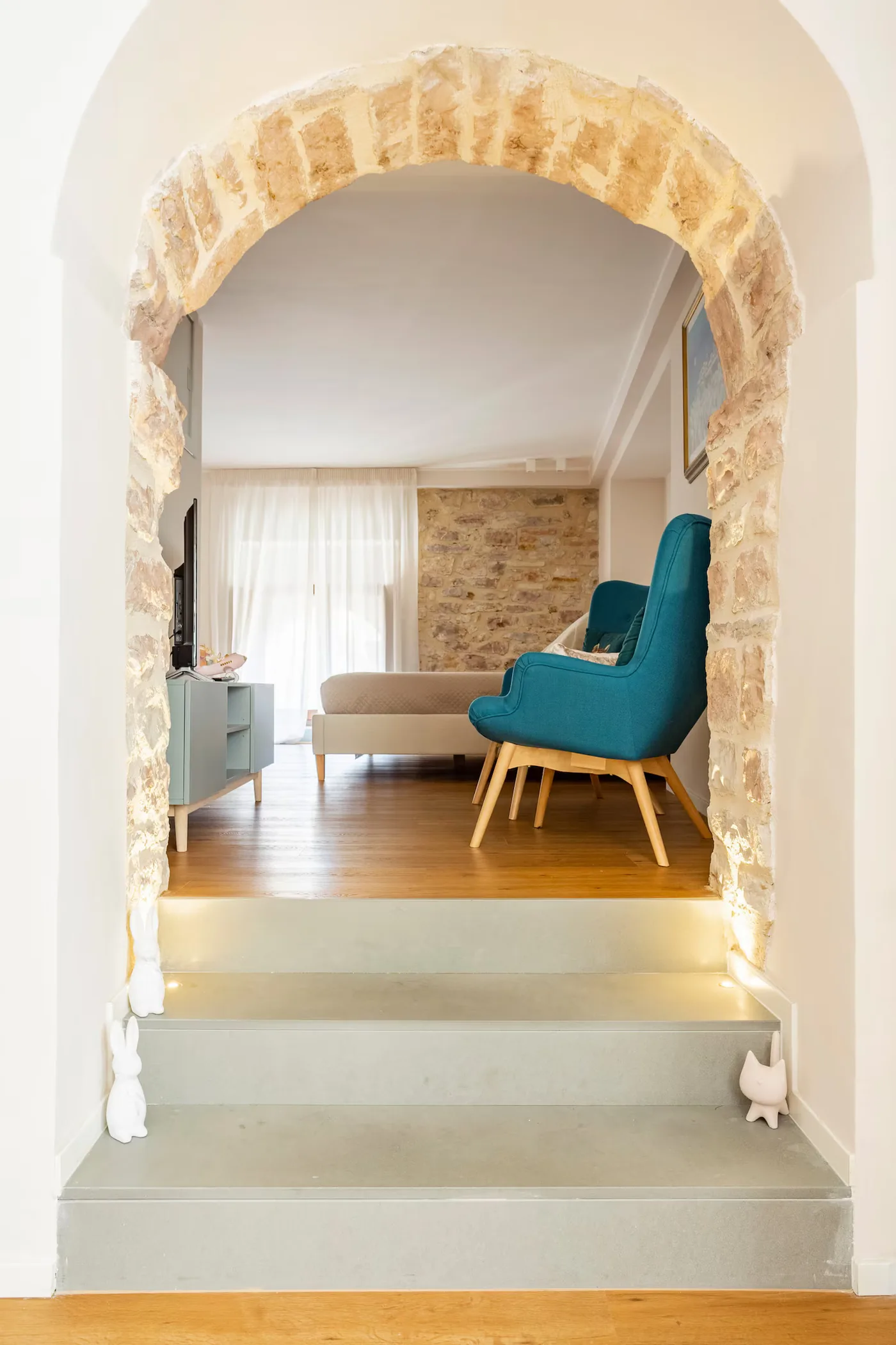 Arco in pietra e gradini verso il salottino del loft