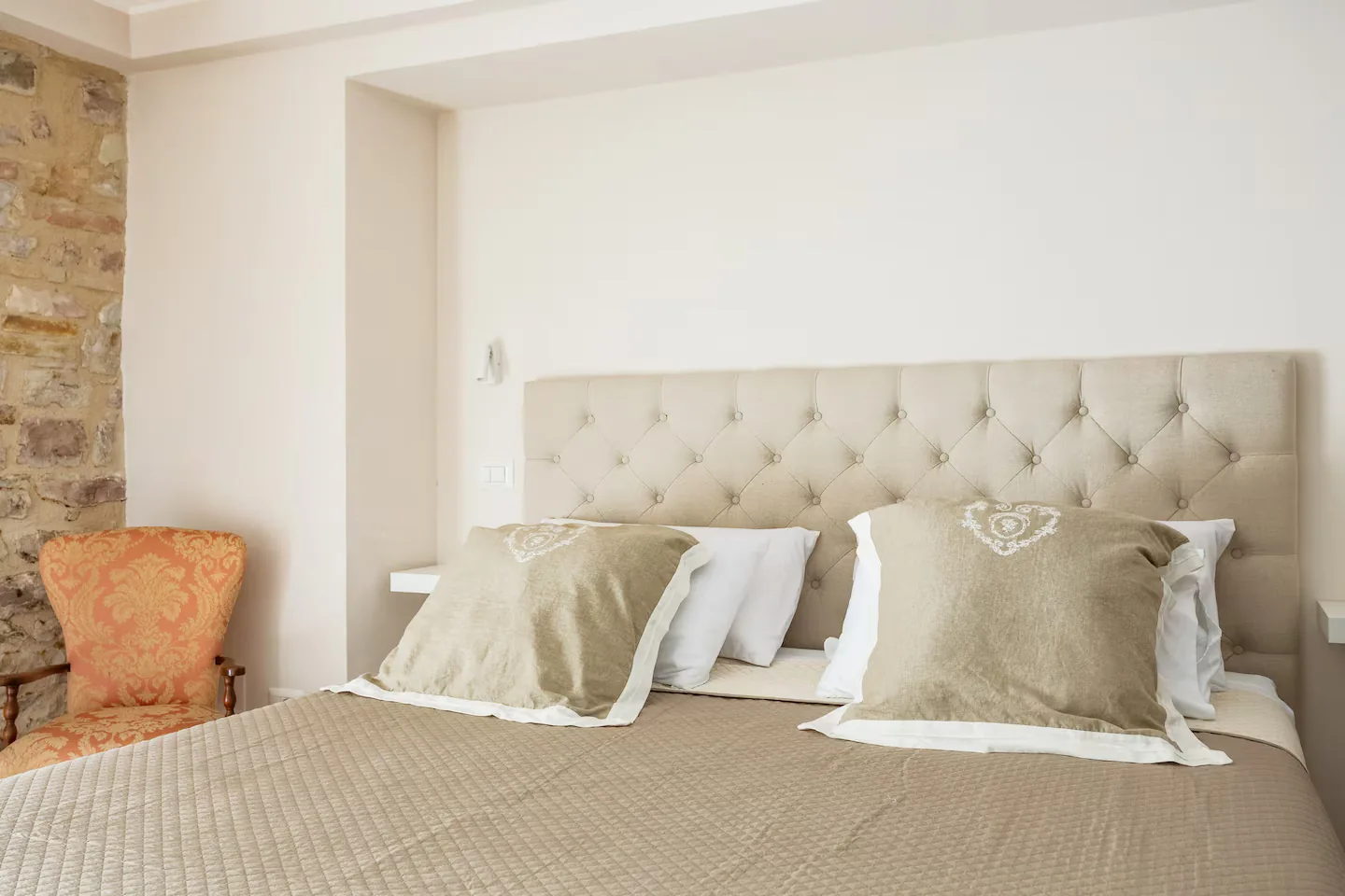Camera del loft Fratello Sole con letto king size e testiera capitonné