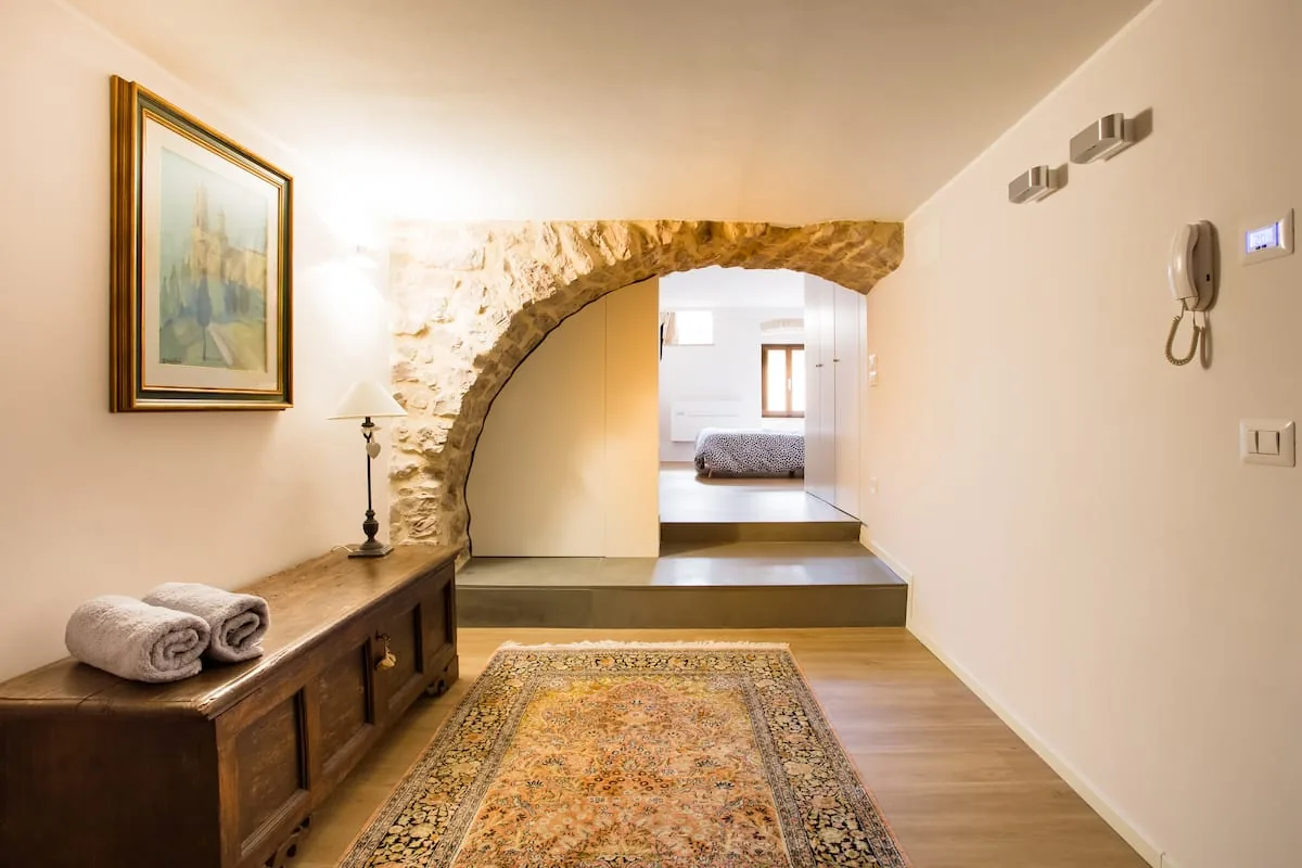 Ingresso di Sorella Luna con arco in pietra e cassapanca antica