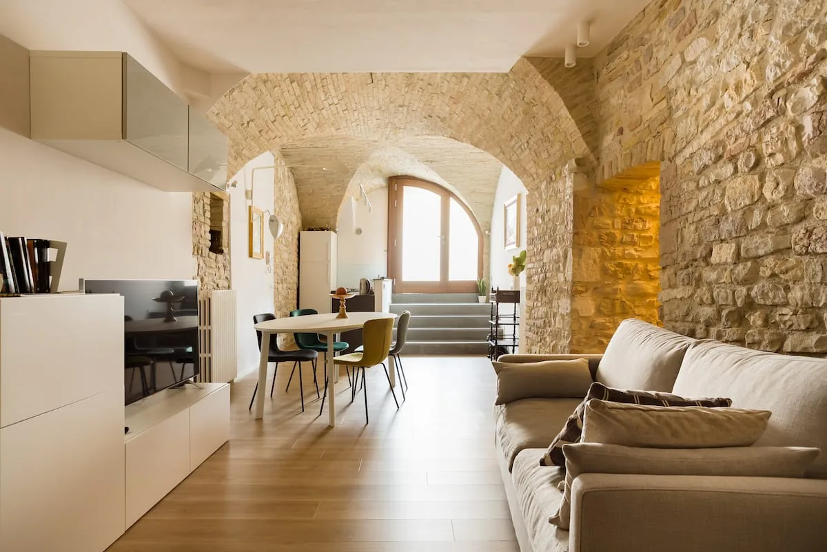 Interno di Sorella Luna con archi in pietra, cucina e zona pranzo